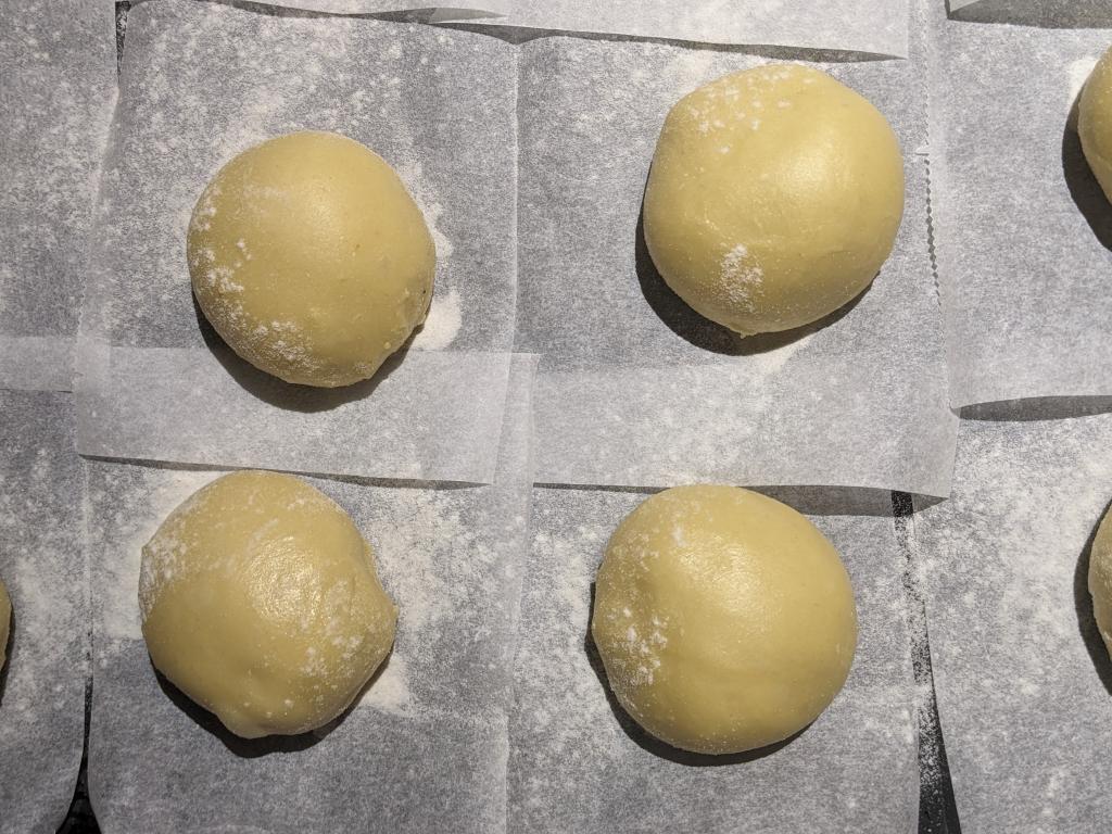 Pączki are resting on the rice flower-covered baking sheet, waiting to be fried next day in the morning.